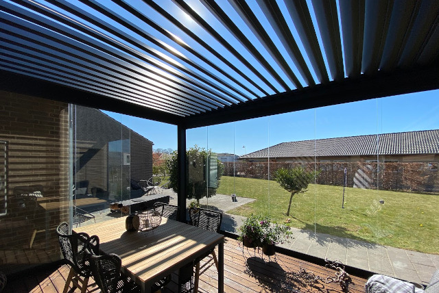 pérgola bioclimática con cortinas de cristal